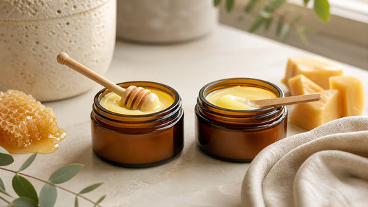 Two unlabelled tallow balm jars with honeycomb, beeswax and linen on a stone vanity